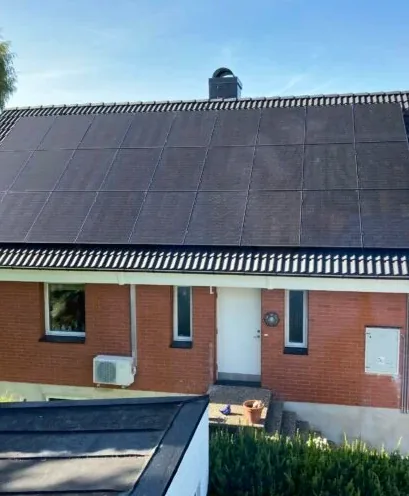 Tegelvilla med helsvarta solpaneler som täcker hela takfallet